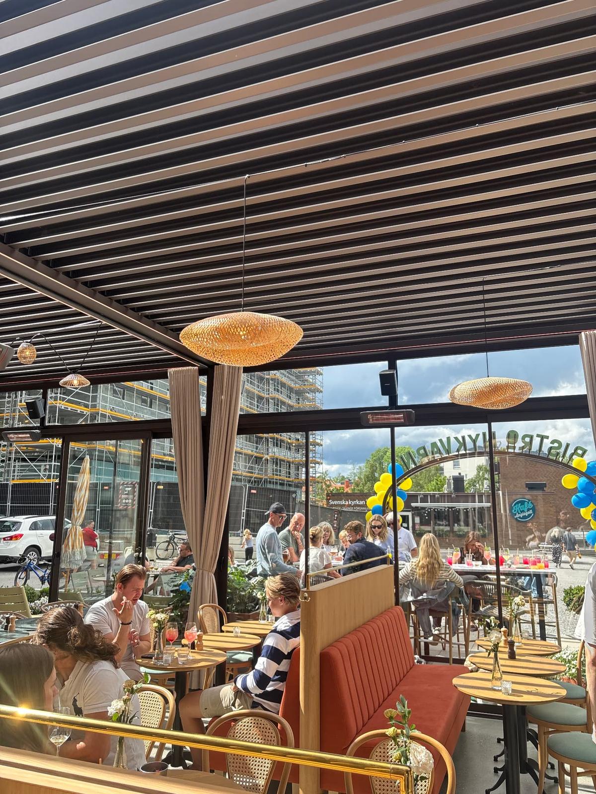 Gäster i Bistro Nykvarns uteservering under pergola
